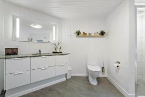 een witte badkamer met een toilet en een wastafel bij 990-Thisted-Spanggardsvej-29 in Torsted +18 foto's
