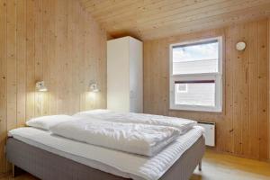 een slaapkamer met een bed in een houten wand bij 990-Thisted-Spanggardsvej-29 in Torsted