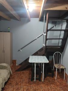 een kamer met een trap en een tafel en stoelen bij Studio Apartamento in Capão da Canoa
