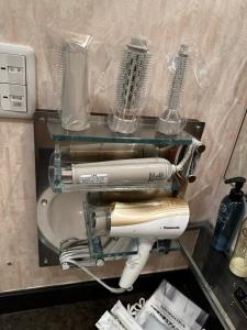 een haardroger op een plank in een hotelkamer bij ホテルemoemo in Fuchu
