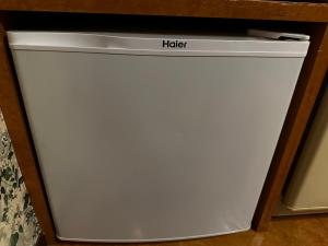 een witte koelkast met het woord 'help' erop geschreven bij ホテルemoemo in Fuchu