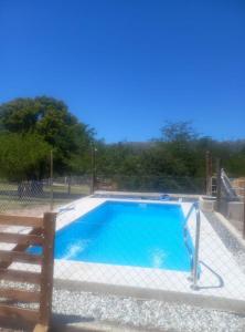 een klein zwembad met een hek eromheen bij Los Lirios in Villa Giardino