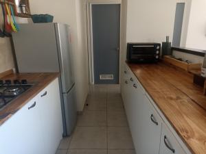 een keuken met witte kasten en een koelkast bij Casa en barrio tranquilo in Osorno