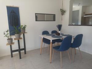 een eetkamer met een tafel en blauwe stoelen bij Casa en barrio tranquilo in Osorno