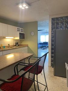 a kitchen with two chairs and a counter and a refrigerator at Caguas Like Home in Caguas