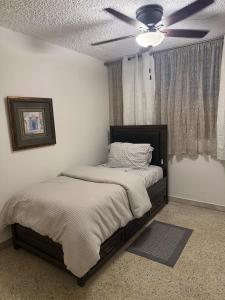 a bedroom with two beds and a ceiling fan at Caguas Like Home in Caguas +26 photos