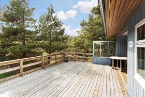 een houten terras met een tafel aan de zijkant van een huis bij 337-Thisted-Hummervej-11 in Thisted