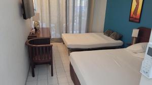 een kleine kamer met 2 bedden en een tafel bij Brise marinotel in Le Diamant