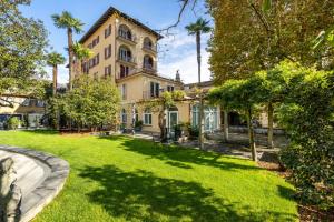an exterior view of a house with a yard at Schloss Locarno - Self Check-In in Locarno