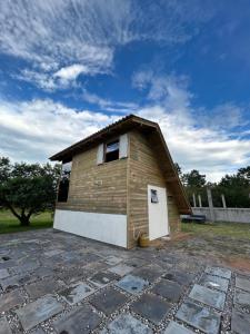 a small building with a roof on a stone patio at pousada Aroeira, G Embaú in Palhoça