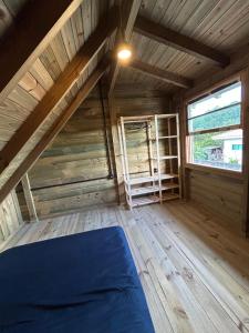 an attic room with a bed and a window at pousada Aroeira, G Embaú in Palhoça
