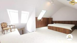 a attic bedroom with a bed and a chair at Mezonet Jarková in Prešov