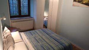 ein kleines Schlafzimmer mit einem Bett und einem Fenster in der Unterkunft La Tavernetta in Ponte della Venturina