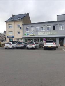 een groep auto's geparkeerd voor een gebouw bij Résidence de la libération in Schifflange