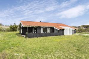 une maison noire avec un toit orange dans un champ dans l'établissement 970-Thisted-Klitstien-47, à Torsted