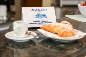 a plate of croissants and a cup of coffee on a counter at Hotel Lu Pitrali in San Teodoro