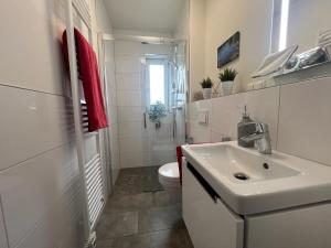 een witte badkamer met een wastafel en een toilet bij Ferienhaus direkt am Diemelsee-Heringhausen-Willingen-Toplage-Sauna-3 Schlafzimmer-2 Terrassen-109 qm-incl Wäsche in Diemelsee +36 foto's