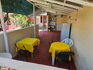 two tables and chairs with yellow tables and a refrigerator at peixes apart in Puerto Iguazú
