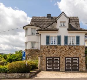 ein weißes Haus mit zwei Garagentüren in der Unterkunft Villa Vulkaneifel in Kelberg