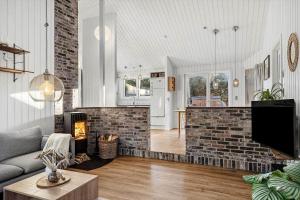 een woonkamer met een open haard en een bakstenen muur bij 1005-Thisted-Spanggardsvej-39 in Torsted