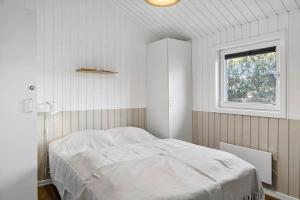 een witte slaapkamer met een bed en een raam bij 1005-Thisted-Spanggardsvej-39 in Torsted +23 foto's