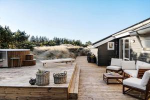 een patio met een bank en stoelen in een huis bij 1005-Thisted-Spanggardsvej-39 in Torsted