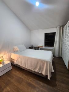a white bedroom with a bed and a window at La divina trinidad - Galeria Wellness Hostal in Cali
