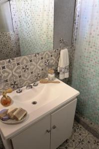 een badkamer met een witte wastafel en een spiegel bij Departamento Loft Costanera in Gualeguaychú