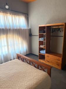 een slaapkamer met een bed en een dressoir met een spiegel bij Departamento Loft Costanera in Gualeguaychú