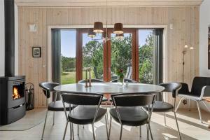 una sala da pranzo con tavolo, sedie e camino di 748-Thisted-Blamunkevej-65 a Thisted Altre 13 foto