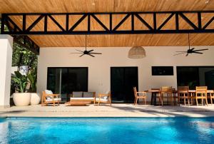 a patio with a table and chairs and a pool at Honu Villas - Nui in Nosara