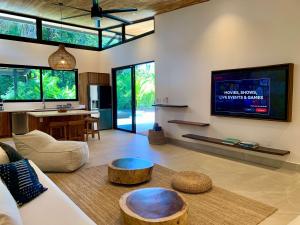 a living room with a couch and a tv at Honu Villas - Nui in Nosara