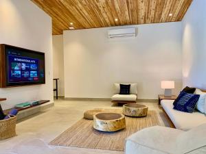a living room with a couch and a tv at Honu Villas - Nui in Nosara +15 photos