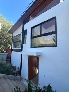 a white house with black windows and a door at Jungle surf Villa in El Zonte