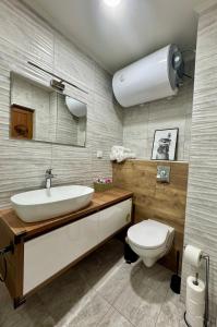 ein Badezimmer mit einem weißen Waschbecken und einer Toilette in der Unterkunft The Golden spot Modern Central Apartment with Garage and Balcony, Quiet Location in Yambol