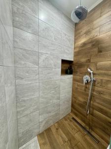 ein Bad mit einer Dusche und Holzwänden in der Unterkunft The Golden spot Modern Central Apartment with Garage and Balcony, Quiet Location in Yambol + 4 Fotos
