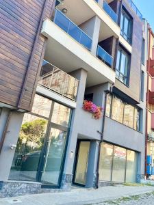 ein Gebäude mit Glasfenstern und einem Balkon in der Unterkunft The Golden spot Modern Central Apartment with Garage and Balcony, Quiet Location in Yambol