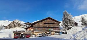 een skihut met auto's in de sneeuw bij Freeride Hostel in Les Crosets