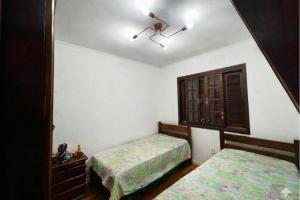 a bedroom with two beds and a mirror at Pôr do Sol - Atibaia in Atibaia