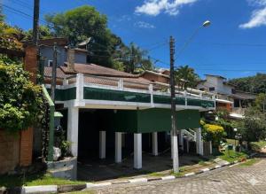 a house with a green and white building at Pôr do Sol - Atibaia in Atibaia