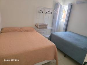 a bedroom with two beds and a window at Flat aconchegante em Itamaracá in Itamaracá +9 photos