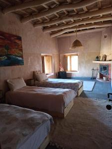 een slaapkamer met 3 bedden in een kamer bij Trésors des Ancêtres in Ibrahene