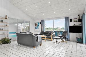 un salon avec un canapé, des chaises et une télévision dans l'établissement 975-Thisted-Klitstien-45, à Torsted