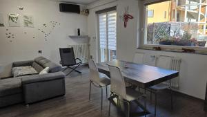 a living room with a table and a couch at GS Valtellina con giardino privato in Morbegno