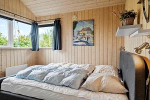 een bed in een kamer met houten wanden en ramen bij 512-Thisted-Sotungevej-4 in Thisted