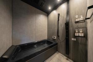 een badkamer met een bad en een douche bij KOS Restaurant & Hotel in Fujikawaguchiko