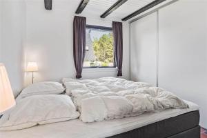 een groot wit bed in een witte kamer met een raam bij 142-Thisted-Pighvarvej-4 in Thisted
