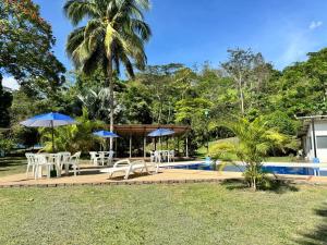 een resort met een zwembad en tafels en parasols bij Hotel Finca la Playa in Villeta
