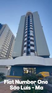 een hoog gebouw met een bord ervoor bij Studio aconchegante no Number One Flat in São Luís