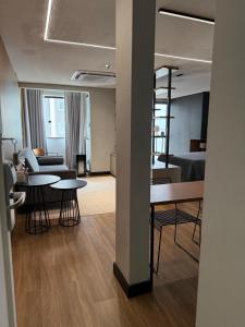 een kamer met tafels en stoelen en een woonkamer bij Studio aconchegante no Number One Flat in São Luís